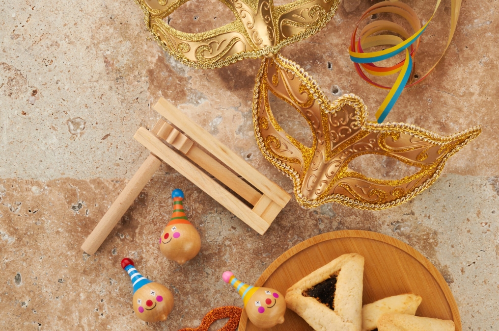 Purim celebration concept. Jewish carnival background. hamantaschen or hamans ears cookies, carnival mask and noisemaker.